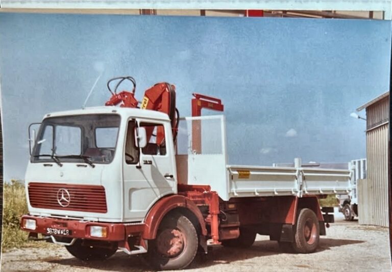 Photographie d'archive — porteur équipé d'une grue auxiliaire et d'un plateau à ridelles